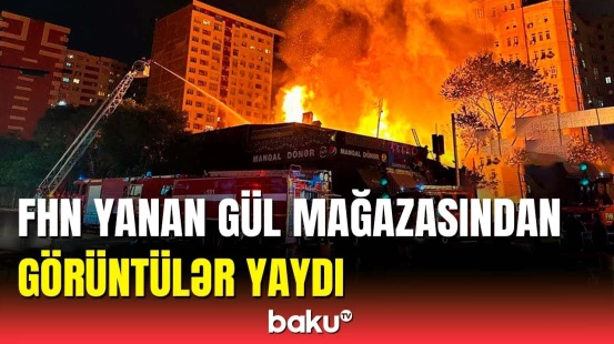 Yanğınsöndürənlər gül mağazasındakı yanğını söndürməyə çalışır